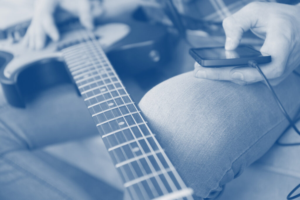 A guitar player using his smartphone