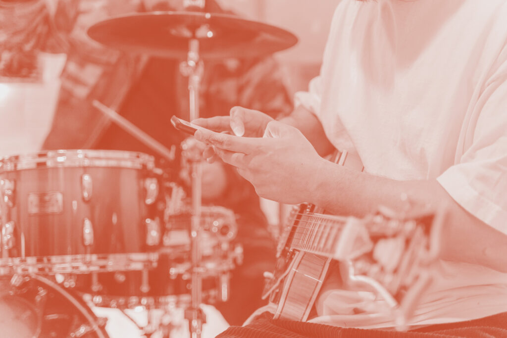 An e-guitar player using his smartphone